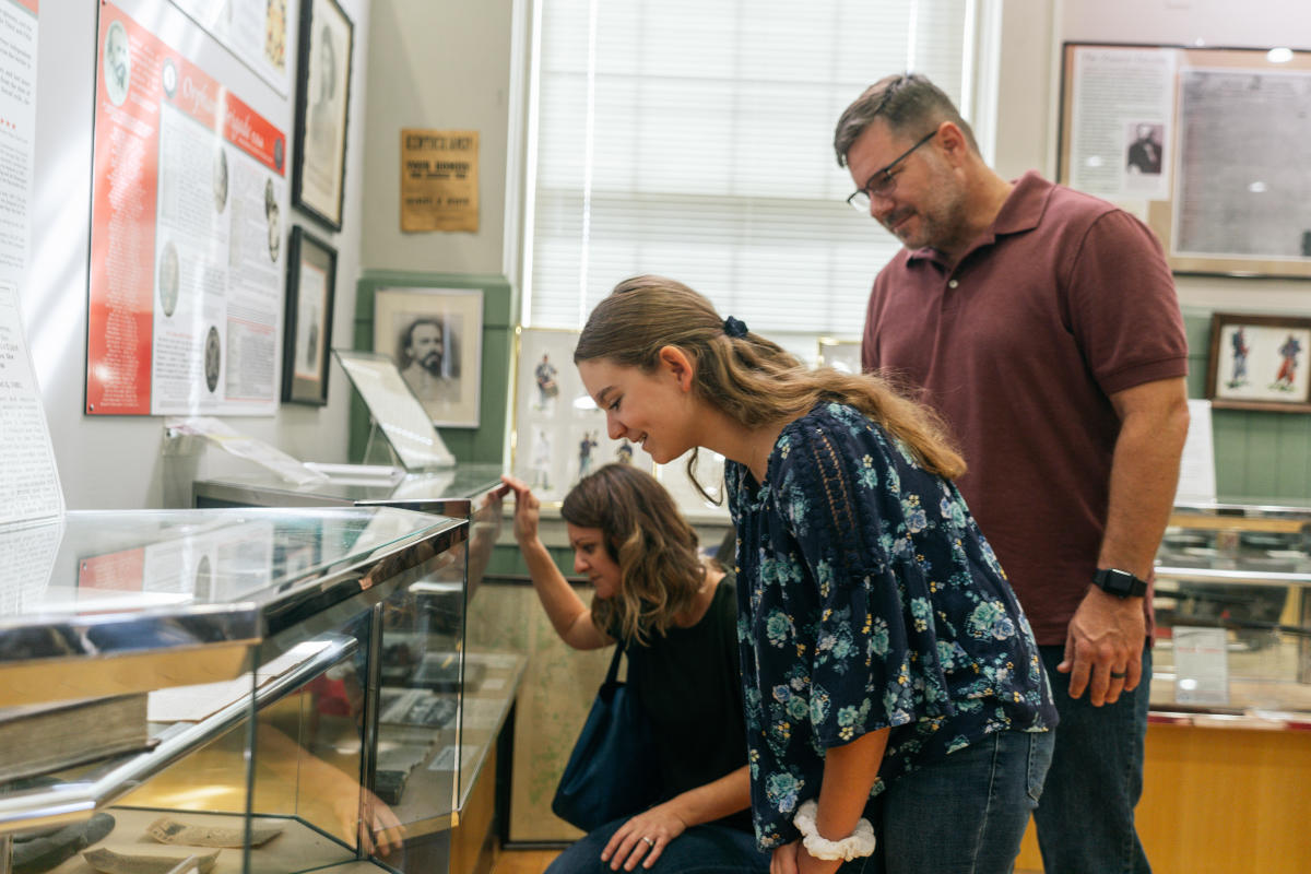 a family looking a display case at the hardin co. history museum