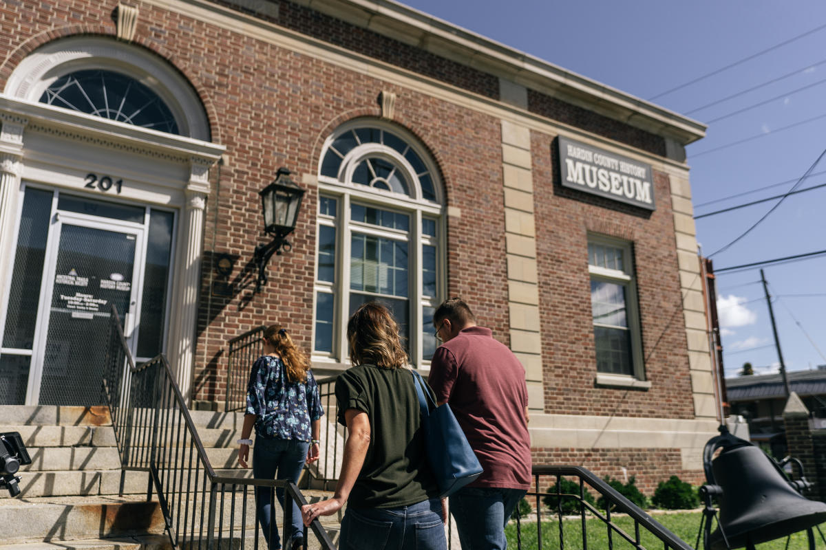 a family walking up the steps to the hardin county history museum