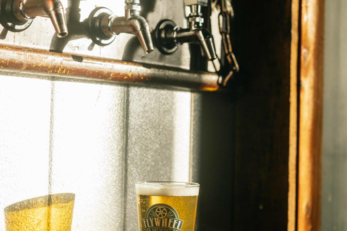 A glass full of beer sitting underneath the tap wall in Flywheel Brewing in Elizabethtown, Kentucky