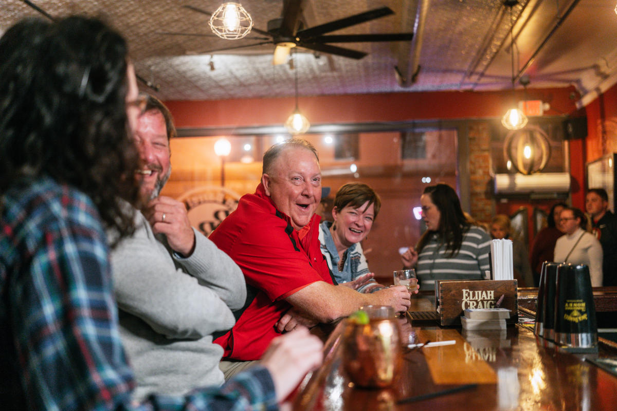 a crowd of people at the bar of bourbon barrel tavern