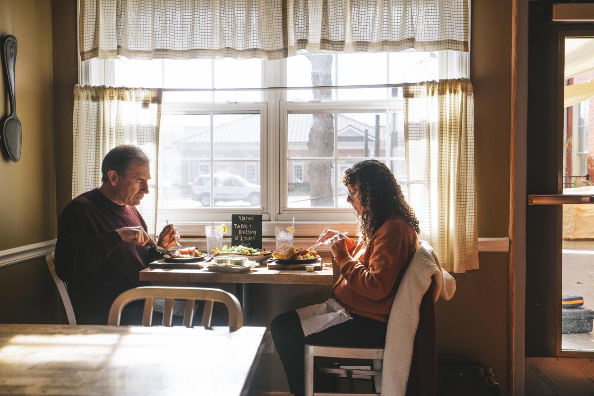 a couple enjoying a meal by a window seat at back home restaurant