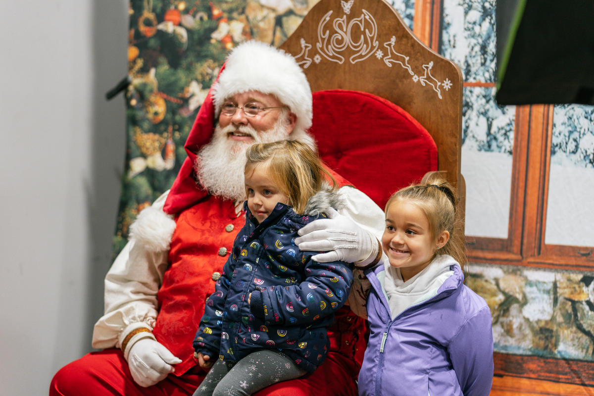 two little girls posing with santa claus