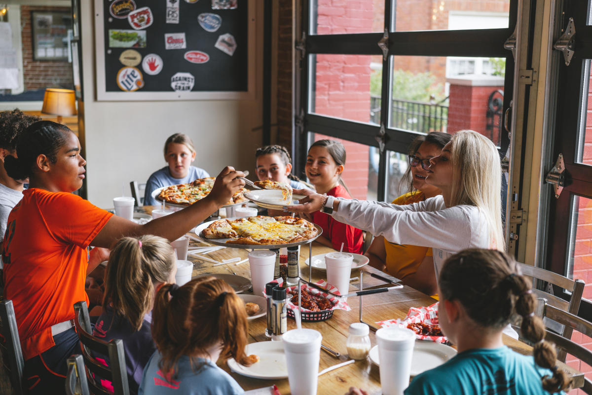 a table passing around pizza at impellizzeris