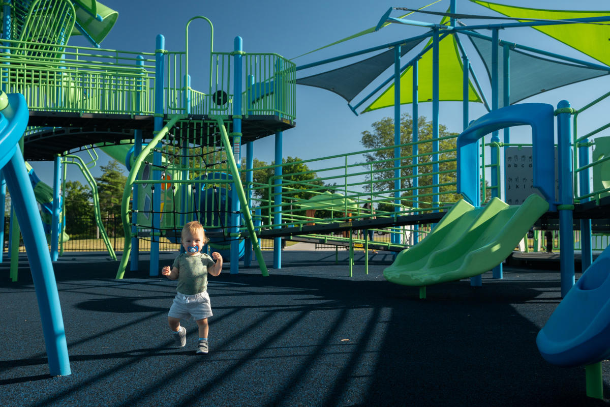 a little boy running around the funtopia playground