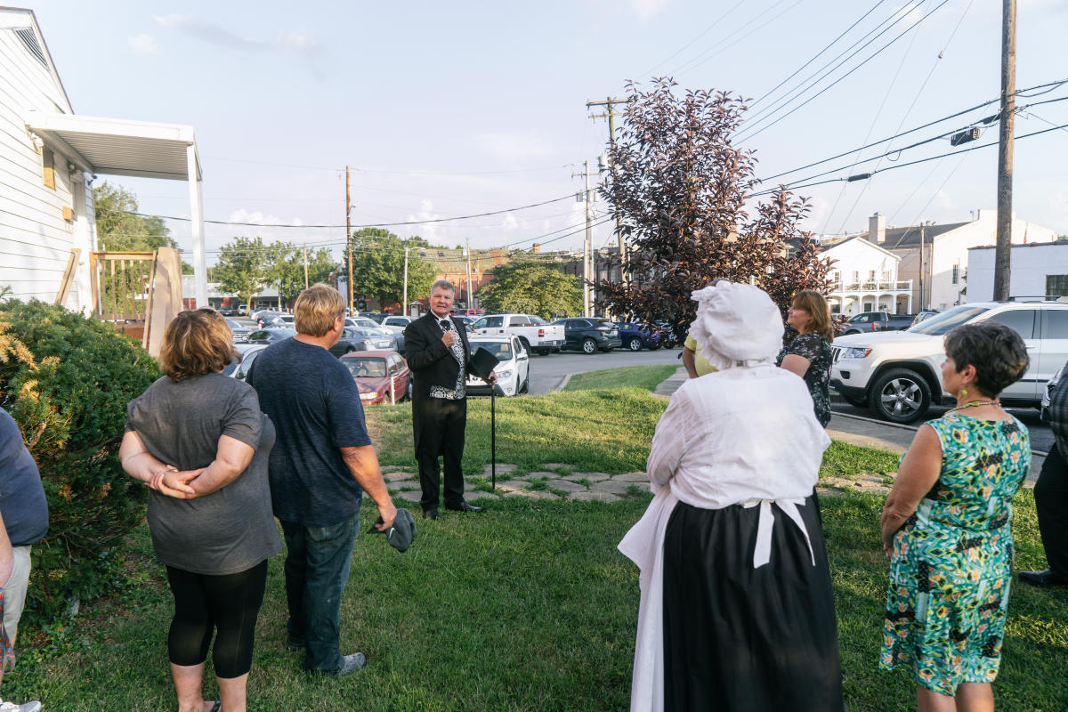 a person in period clothing speaking to participants of the historic walking tour