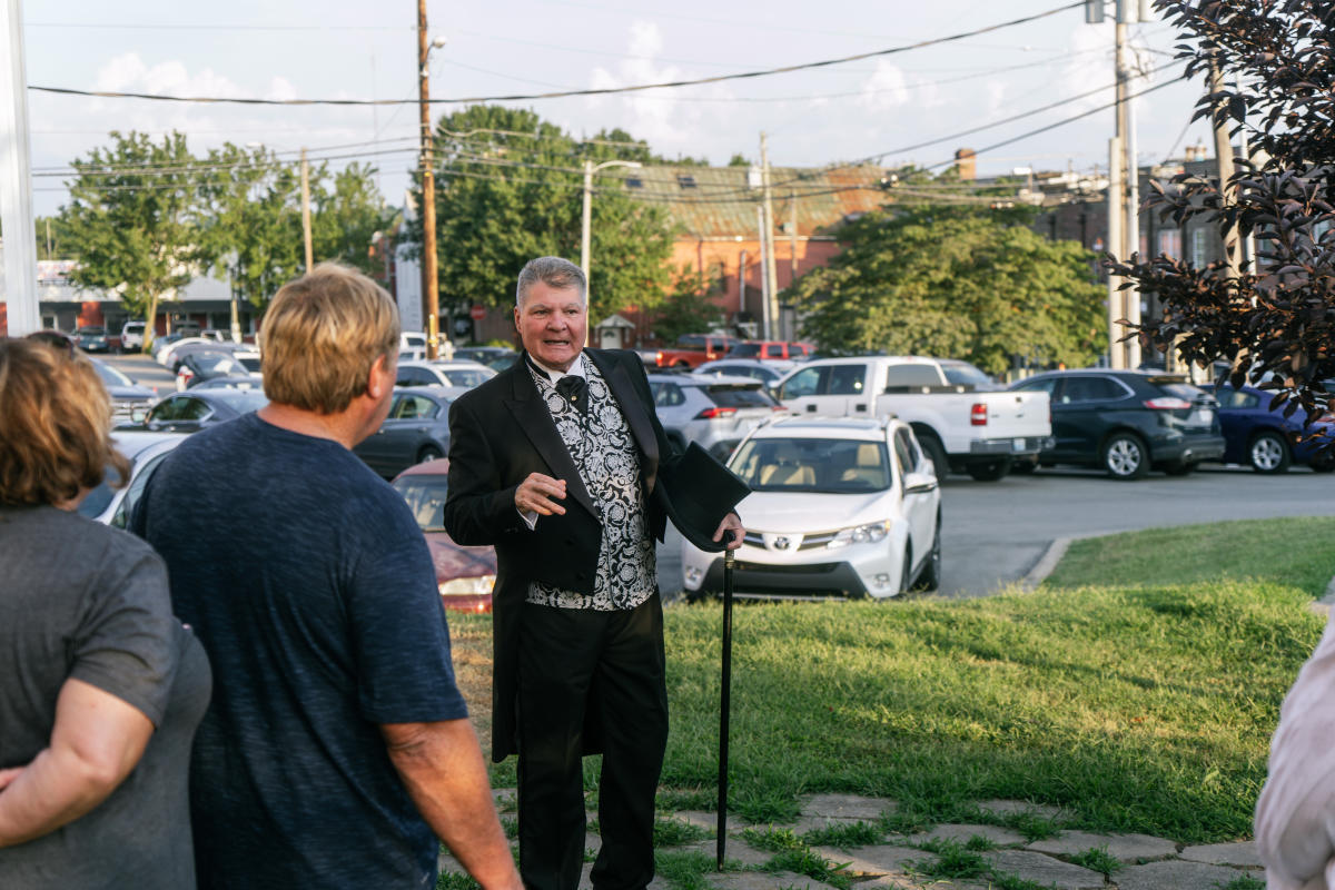a person in period clothing speaking to participants of the historic walking tour