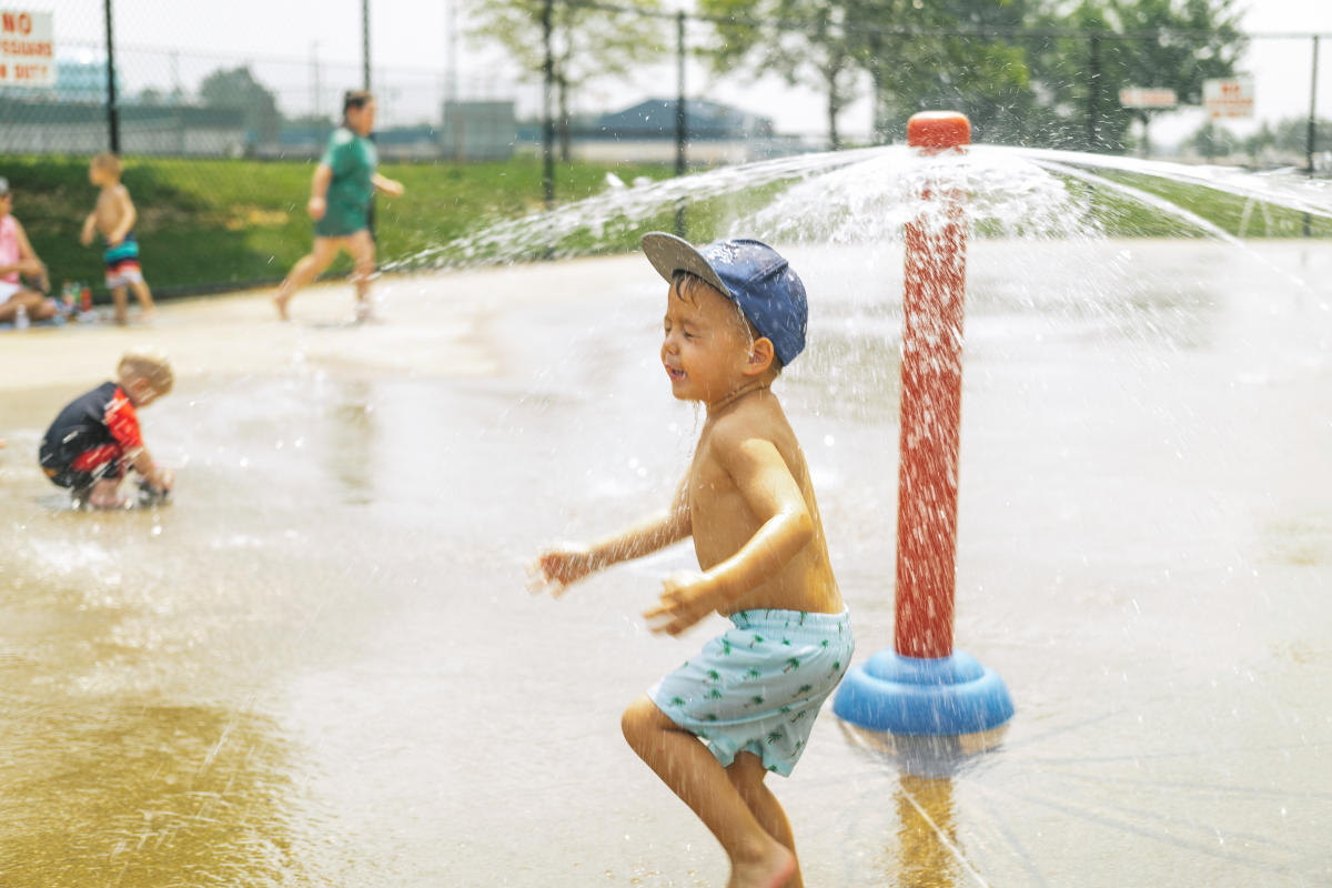 little boy running through the splash pad at american legion park