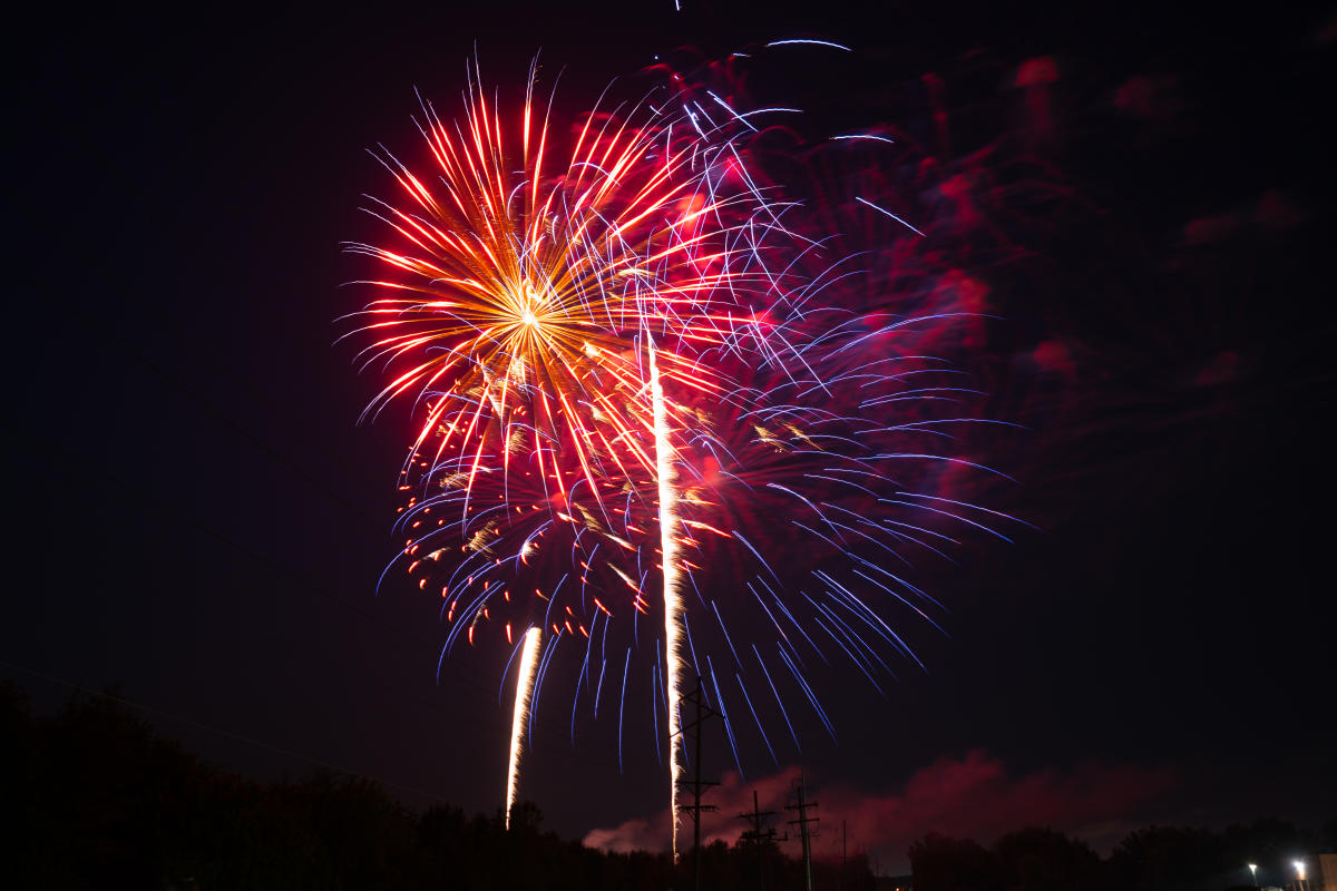 purple, red, and orange fireworks in the night sky