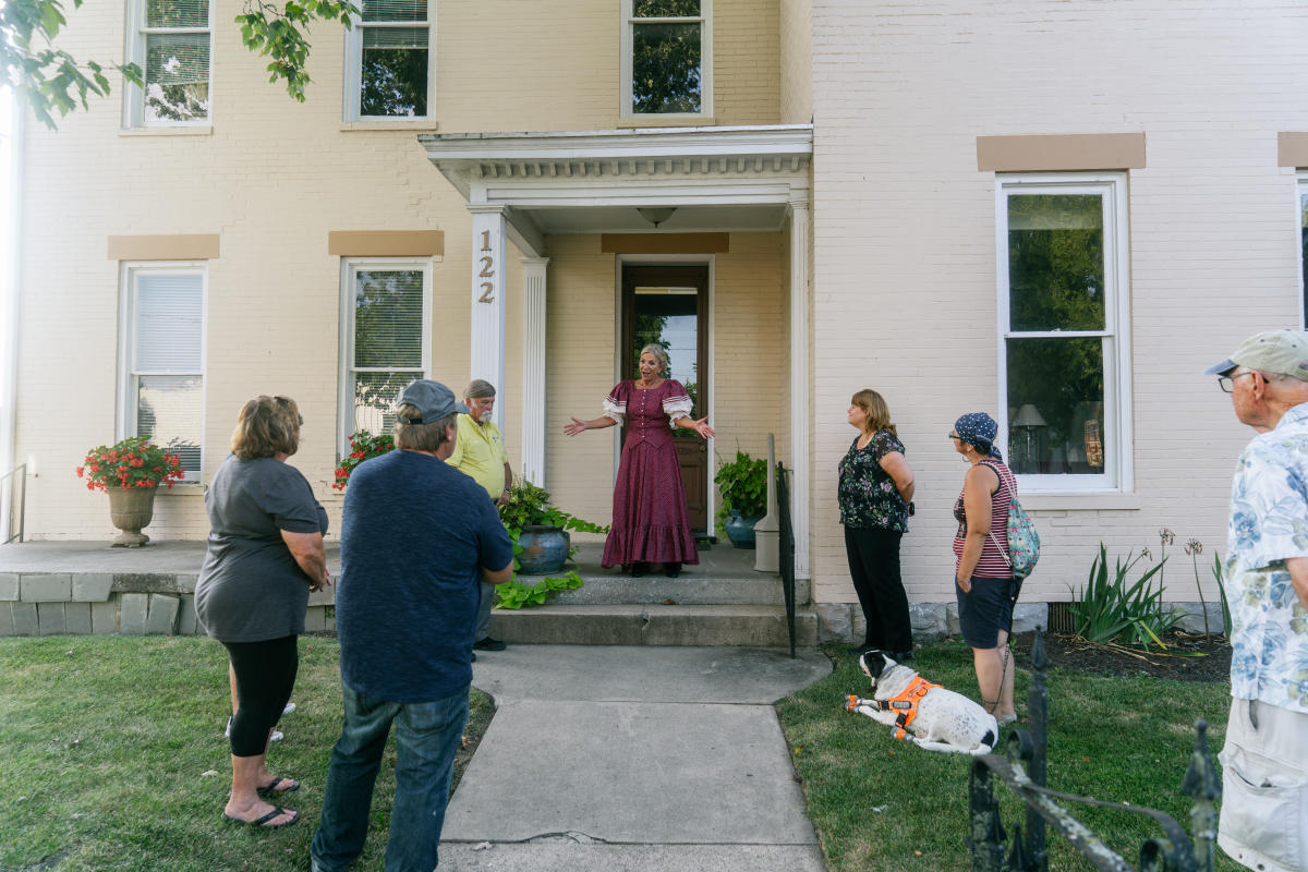 a person in period clothes speaking to participants of the historic walking tour
