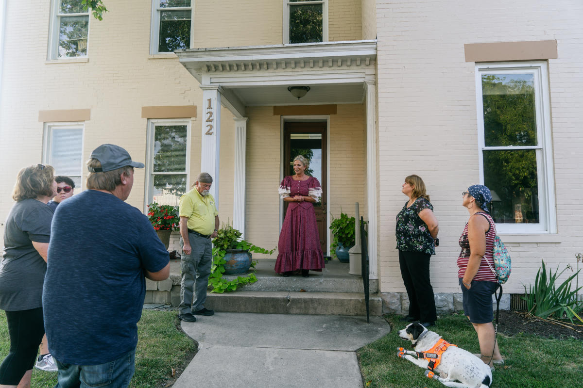 a person in period clothing speaking to participants of the historic walking tour