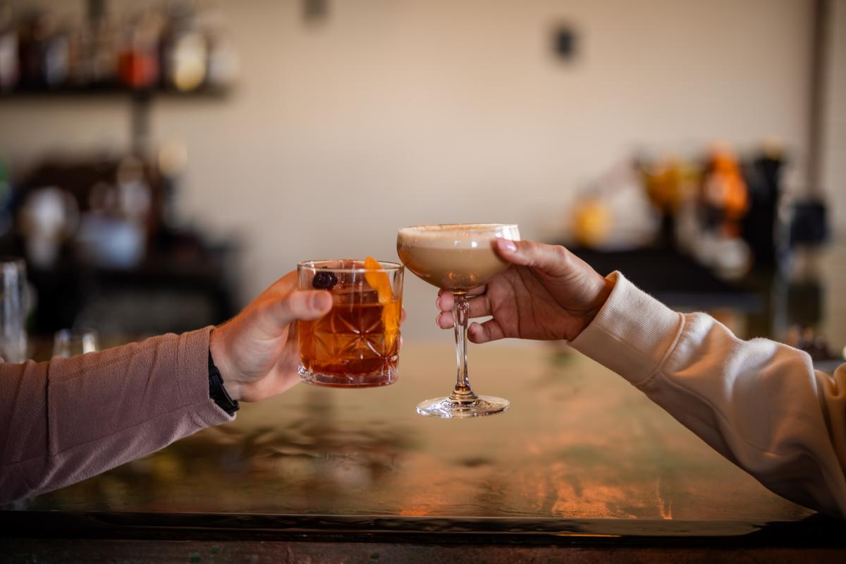 Two drinks being clinked at Revival Vintage Spirits Bar in Downtown Elizabethtown, KY.
