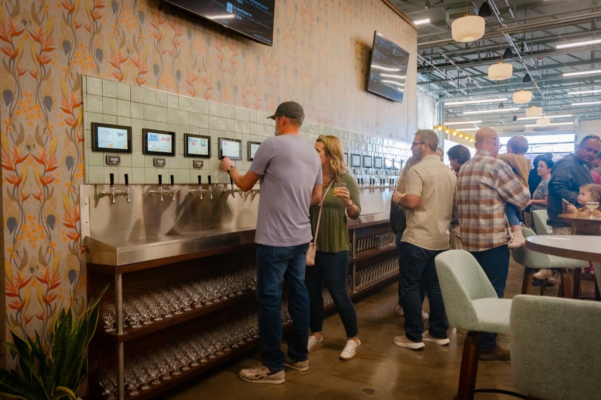 People standing in line at the self-pour taps inside of Social on Main in Downtown Elizabethtown