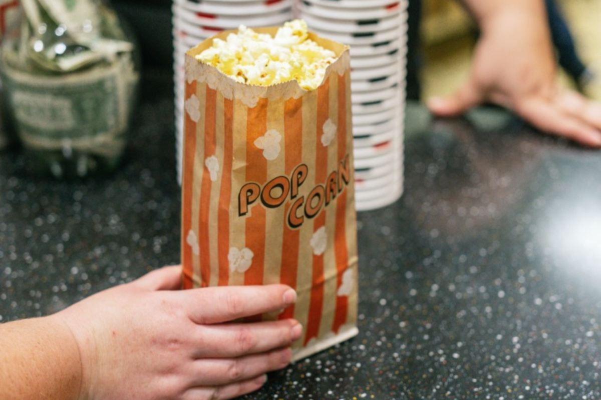 popcorn being handed to a customer at the historic state theater