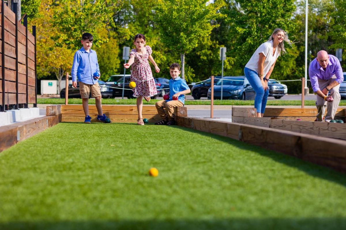 Family playing bocce ball outside at HubHaus in Downtown Elizabethtown, KY.