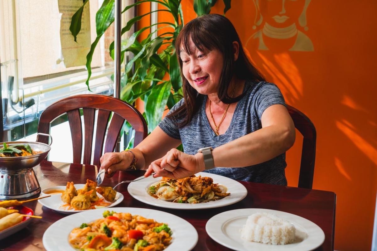 A woman eating food at 2bThai located in Elizabethtown, KY