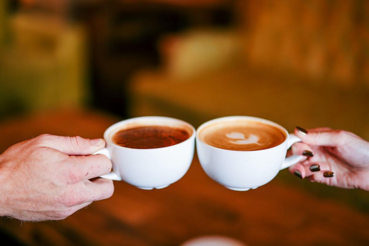 Two coffee cups cheersing at Vibe Coffee shop in Downtown Elizabethtown, Kentucky.