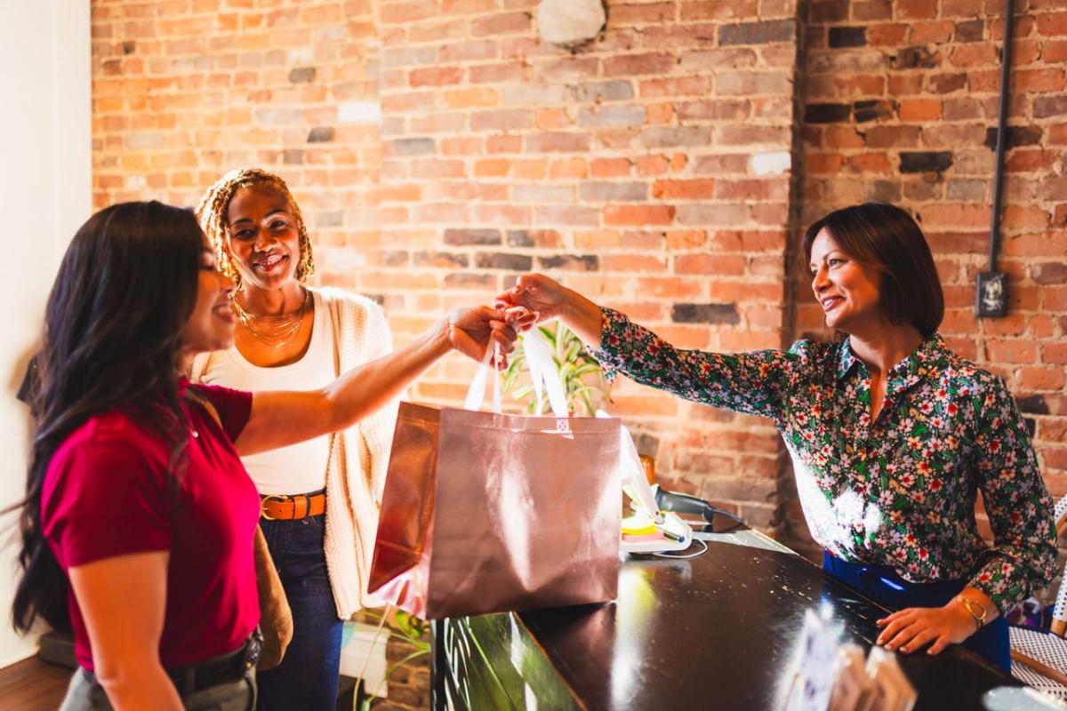 Woman being given a shopping bag at Raiment & Boone, located in Downtown Elizabethtown, KY