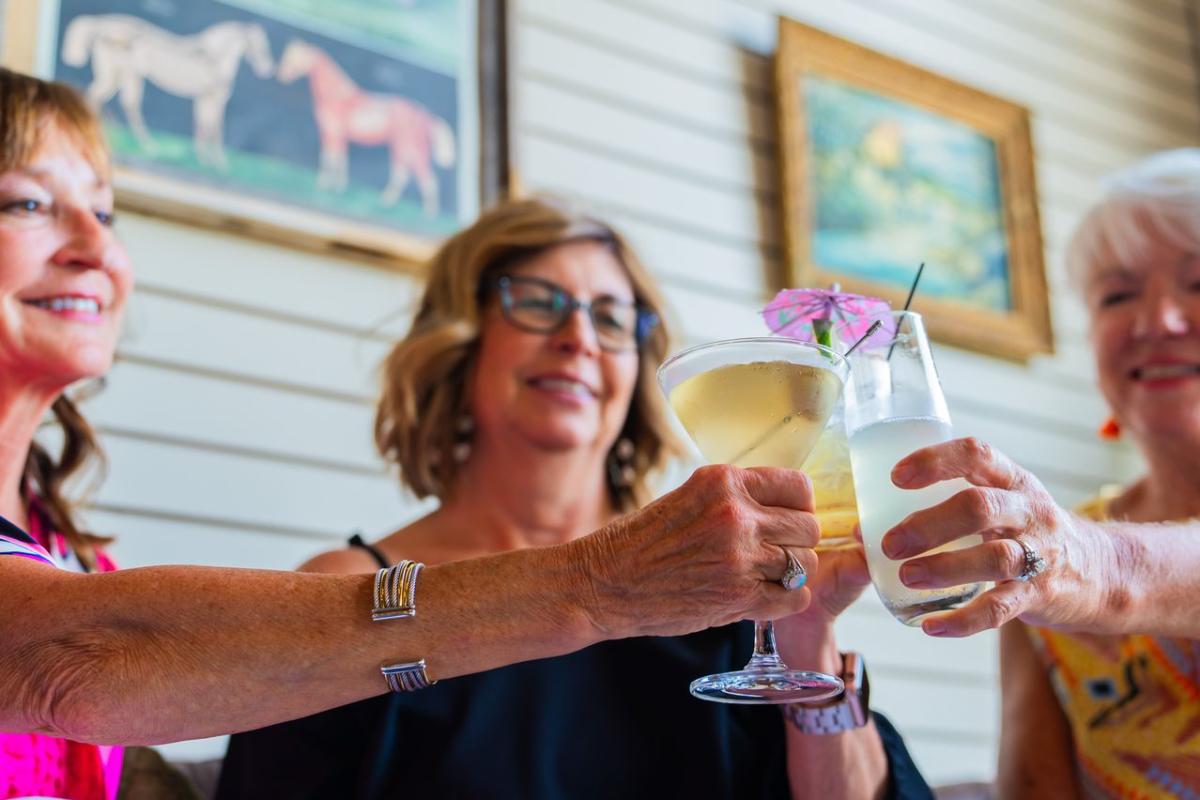 People cheersing their drinks at Revival Vintage Spirits bar in Downtown Elizabethtown, KY.