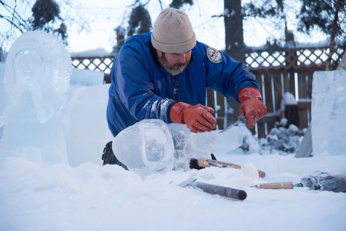 Artist carving ice sculpture at World Ice Art Championships in Fairbanks Alaska.