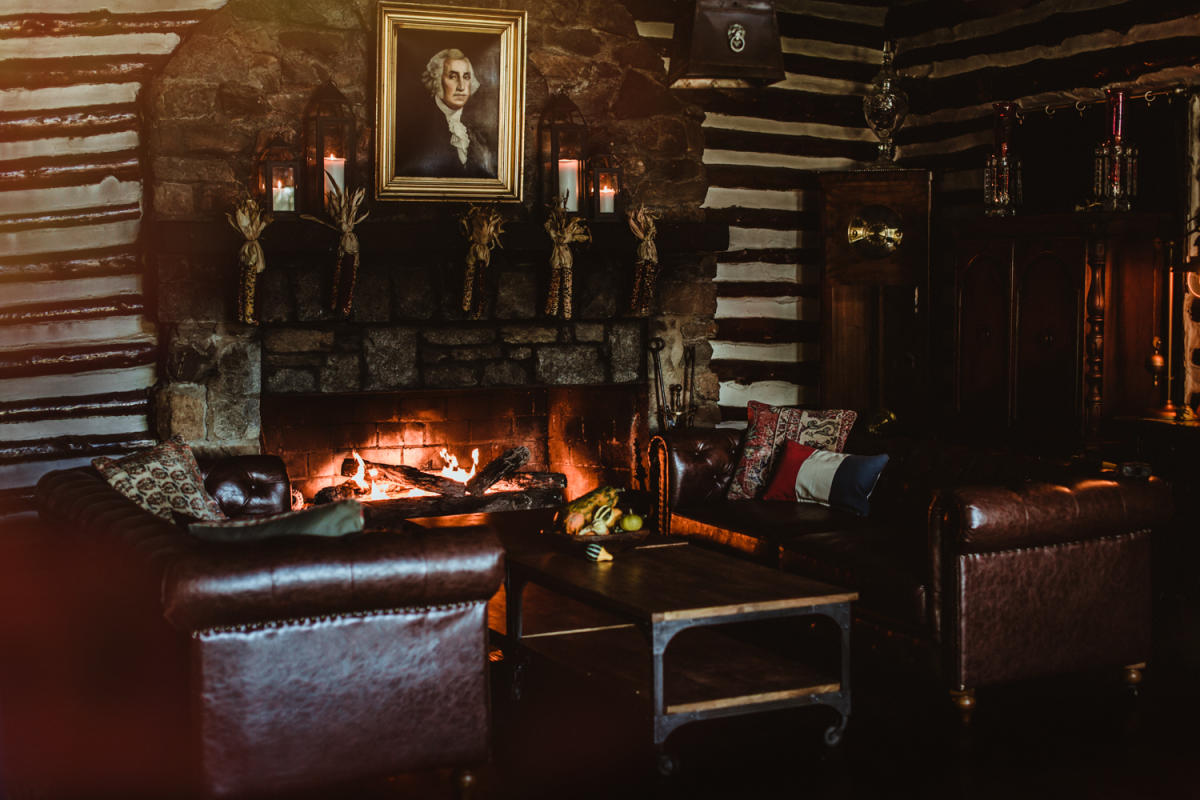 historic section of restaurant with a lit fireplace and leather couches