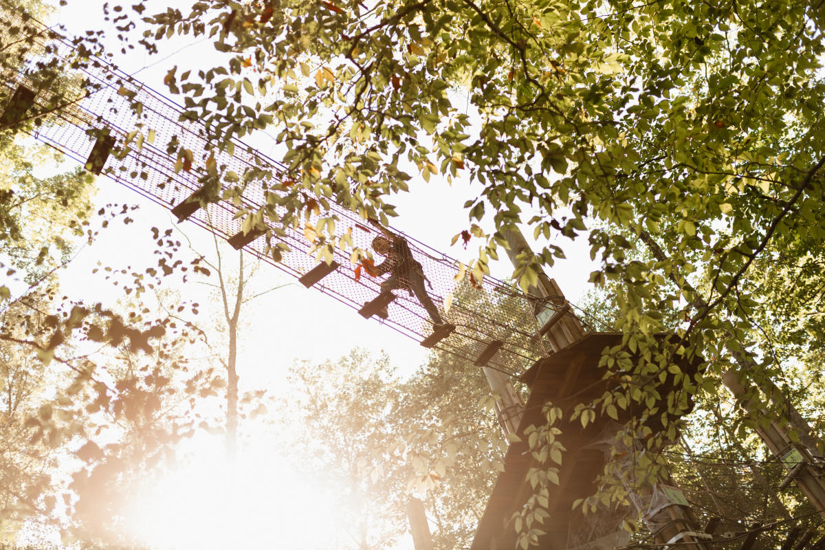 Girl on the tree top zipline course.