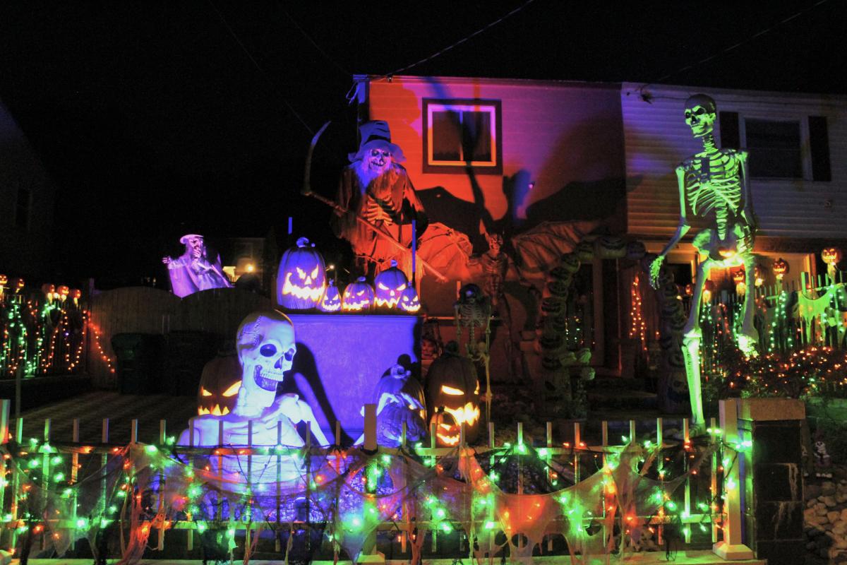 Skeletons, green and purple and orange flood lights, jack o lanterns and other Halloween style decorations