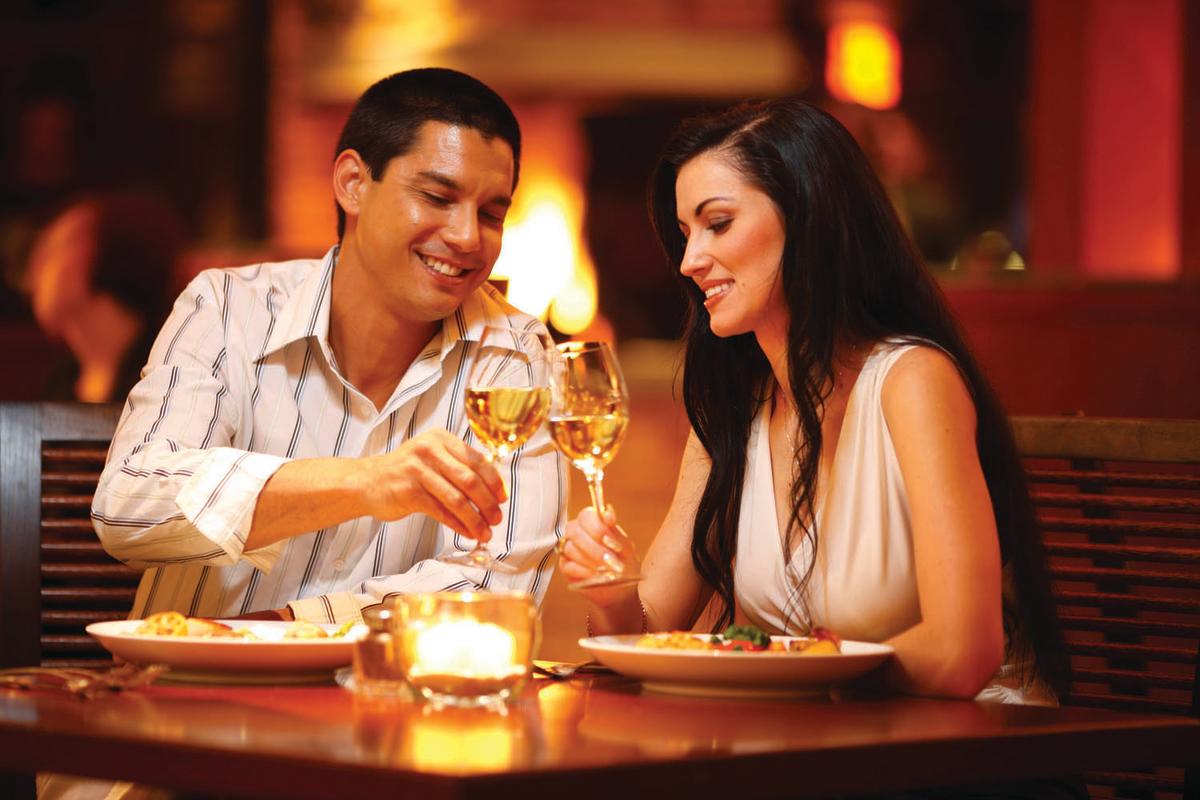 Dining Couple Toasting Wine in Front of a Fire