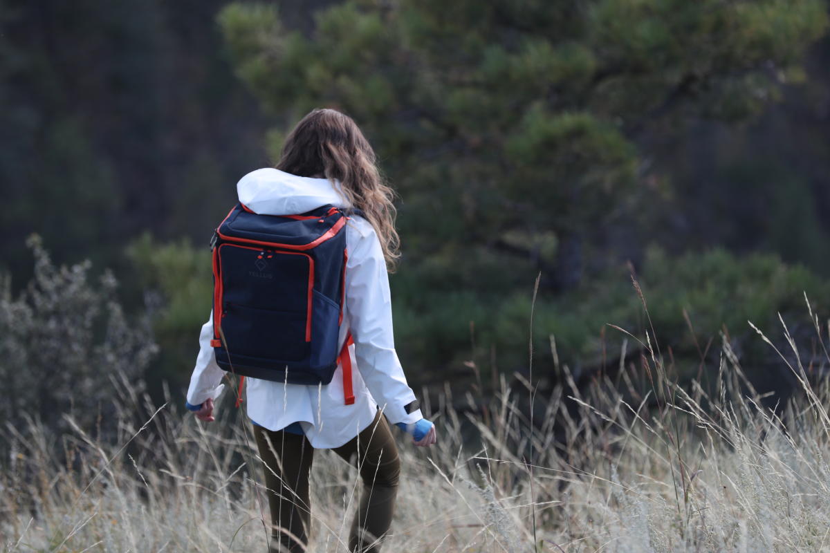 A woman hiking away from the camera in a Tellus backpack