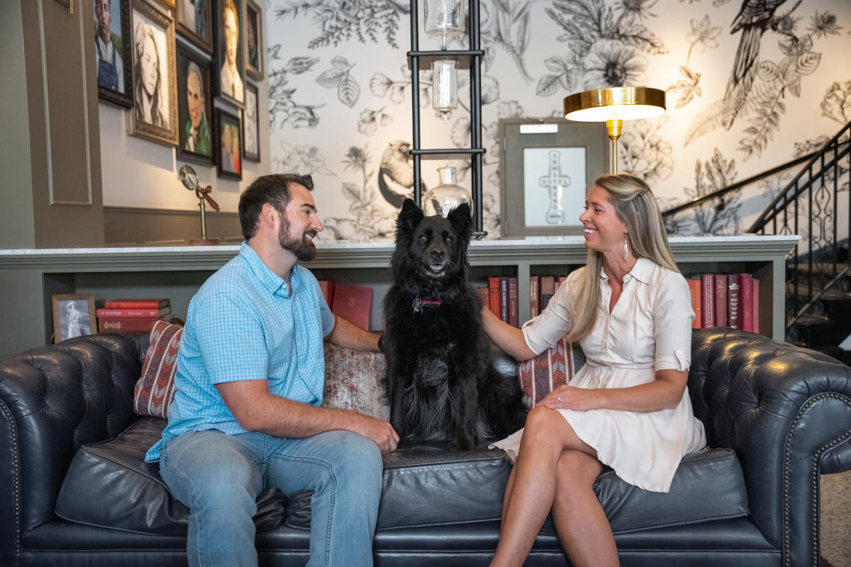 A couple sits in the Armstrong Hotel lobby with their dog