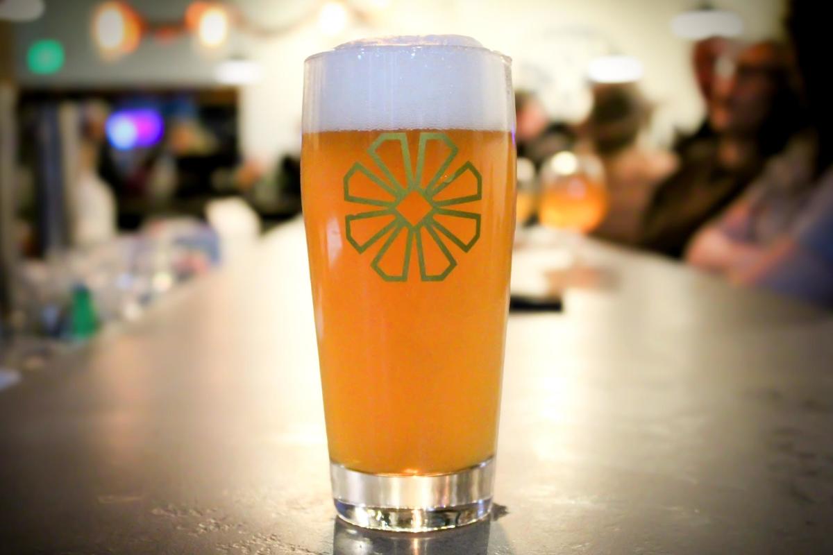 A beer glass filled with amber-colored beer with foam at top