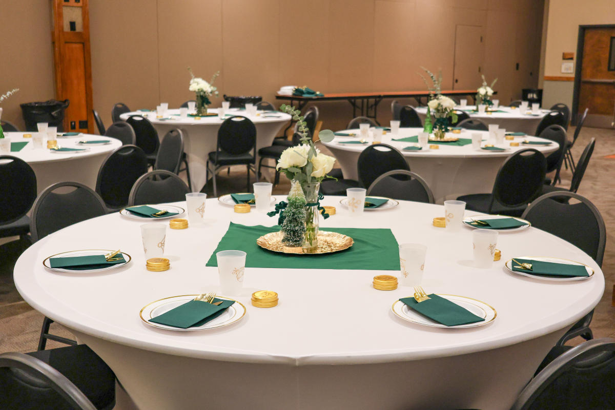 A set table decorated with green and gold accents.