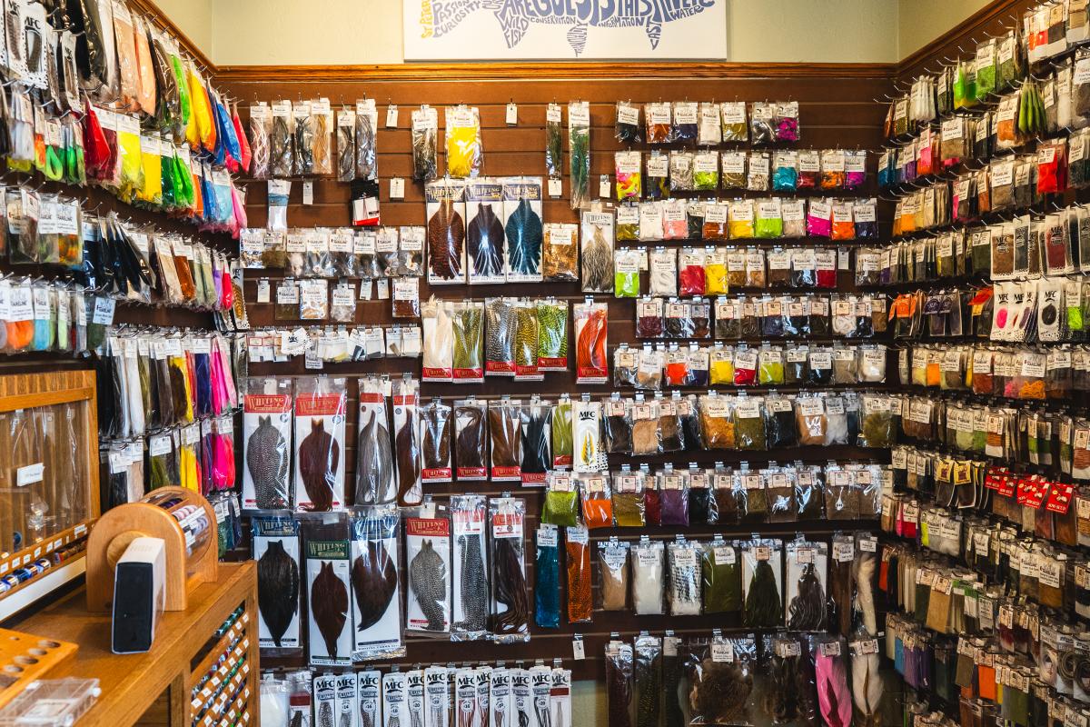 A photo of a fishing store's fly tying supplies like string and feathers.
