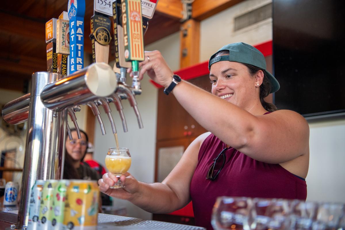 a person pouring their own beer at a new belgium tour
