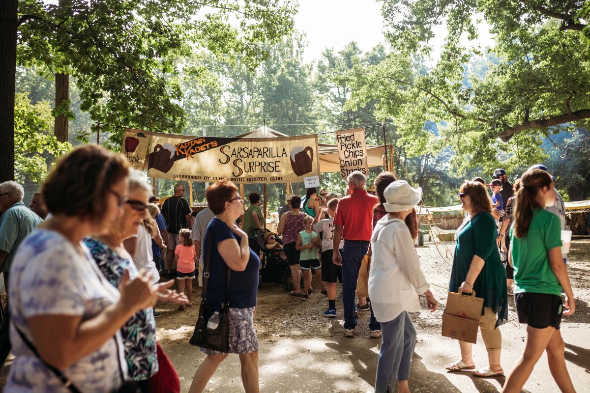 Individuals walking past a food vendor at the Johnny Appleseed Festival - a period authentic festival in Fort Wayne, Indiana.