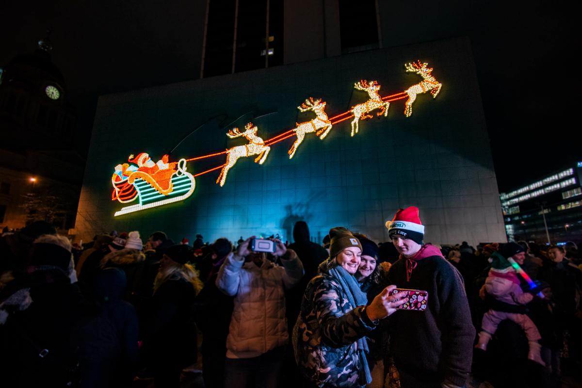 Family taking a selfie with the PNC Santa display at Night of Lights