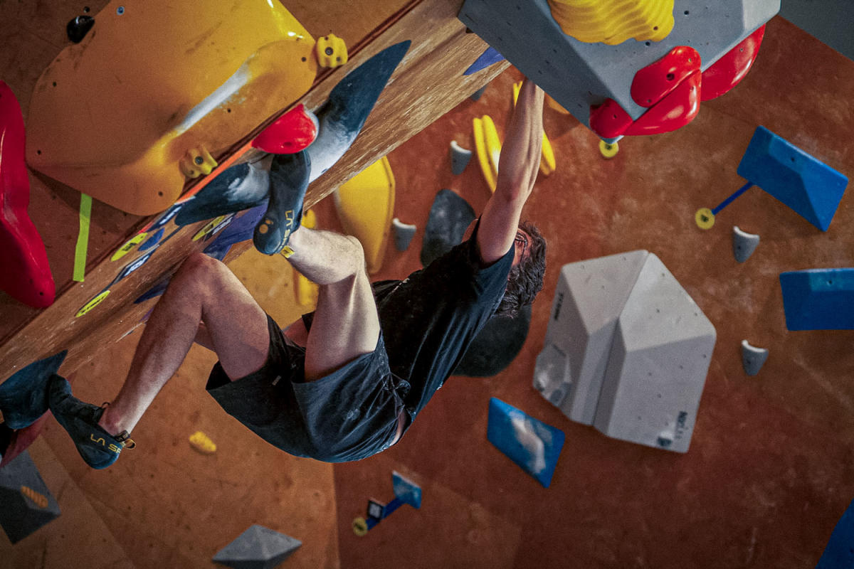 Man climbing a diagonal overhanging wall at Summit City Climbing Co. in Fort Wayne, Indiana.