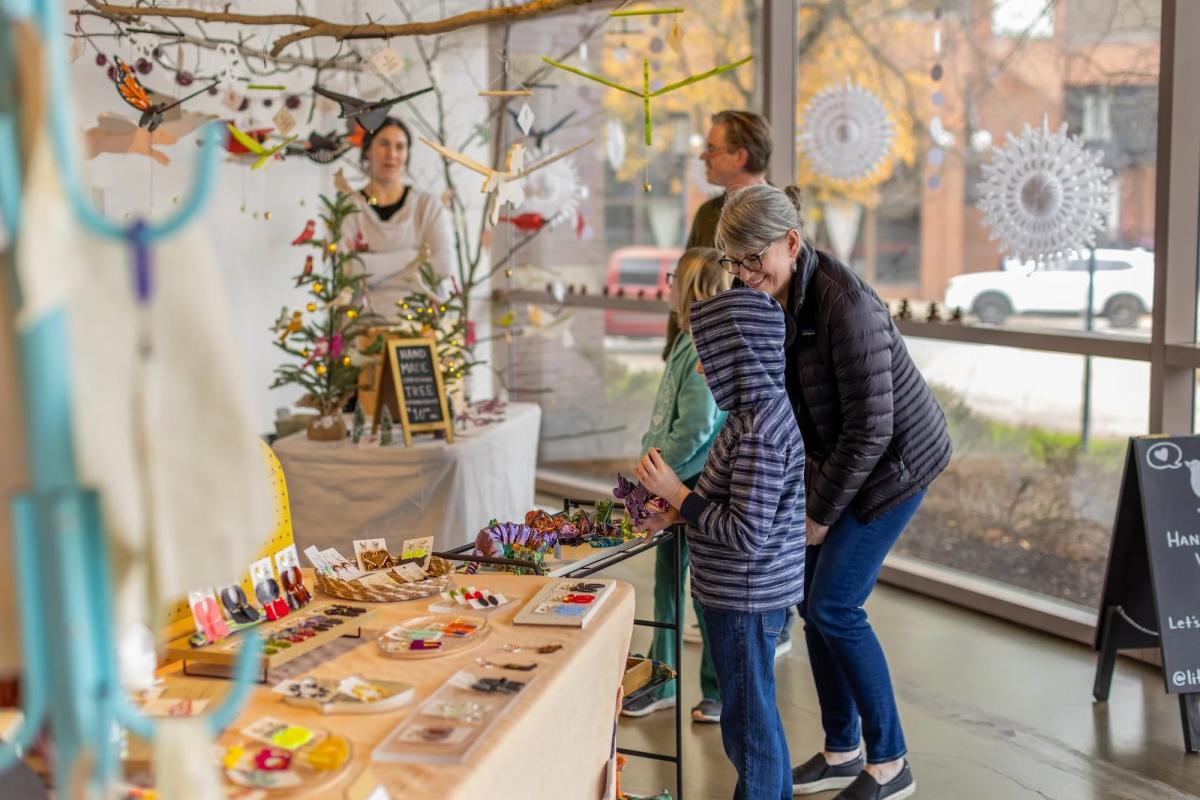 A woman and children browsing the Artlink Winter Market in downtown Fort Wayne, Indiana.