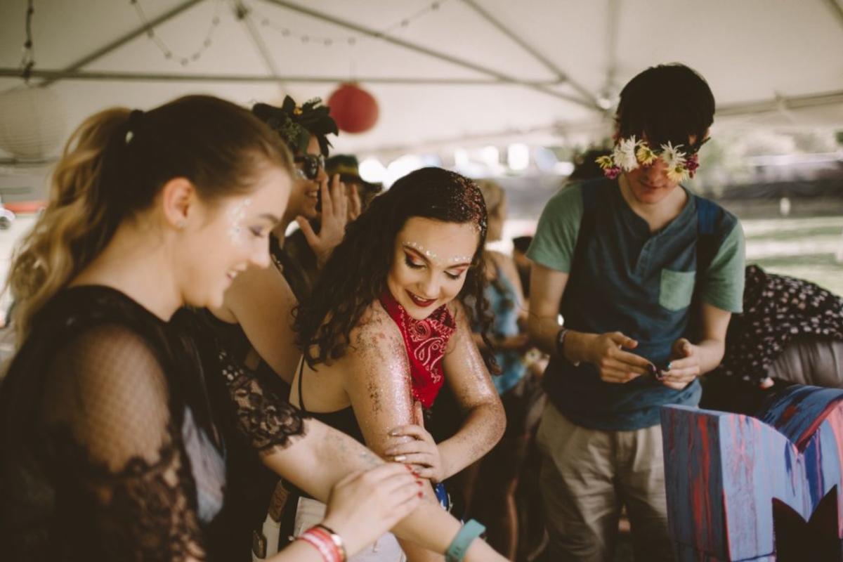 Festival goers at Middle Waves apply glitter