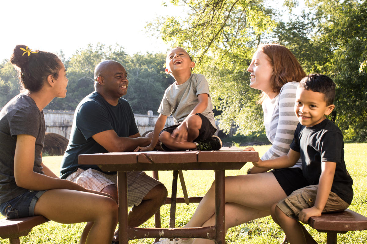 Family sitting at a park picnic table in Frederick, MD