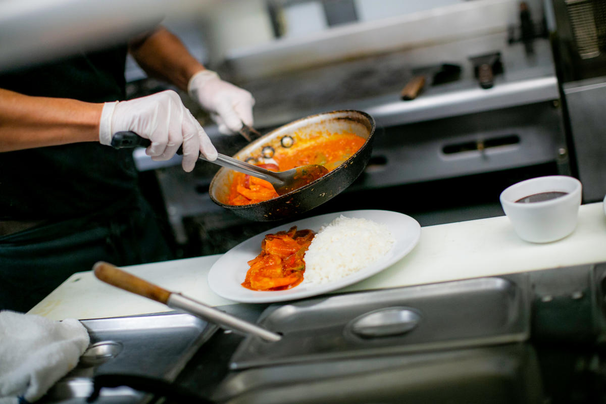 A chef preparing a plate at Sabor De Cuba