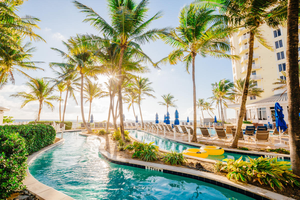 Exterior view of pool and palm trees at the Pelican Grand in Fort Lauderdale, FL