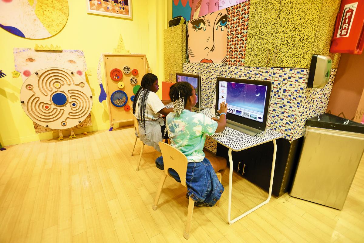 Two kids engaged at some desktops at Young At Art