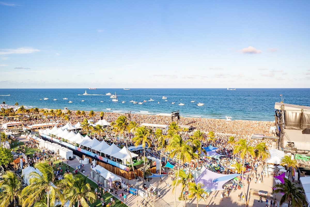 Aerial photo of crowds of listeners on Fort Lauderdale Beach with boats anchored in the waters off-shore
