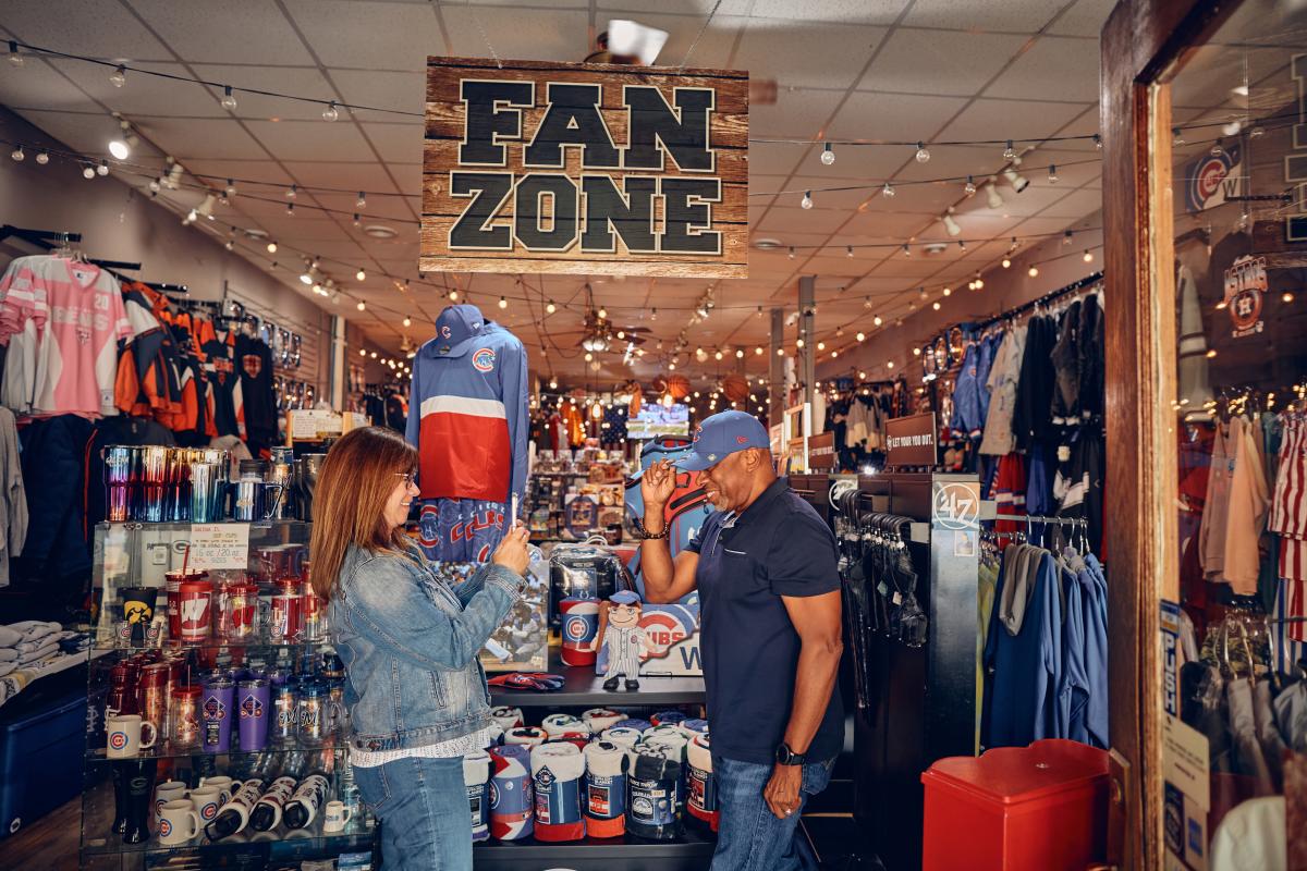 Two people trying on hats in a sports shop.