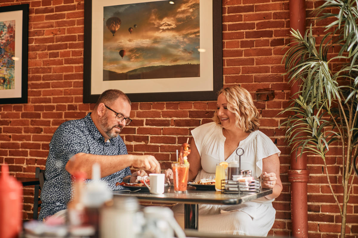 Two people sitting at a table, enjoying breakfast.