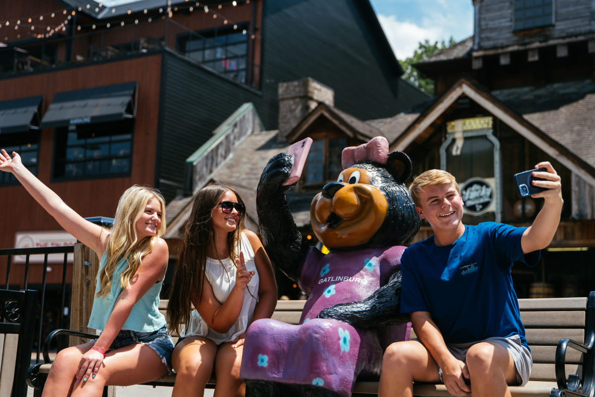 Friends on parkway in front of bear statue