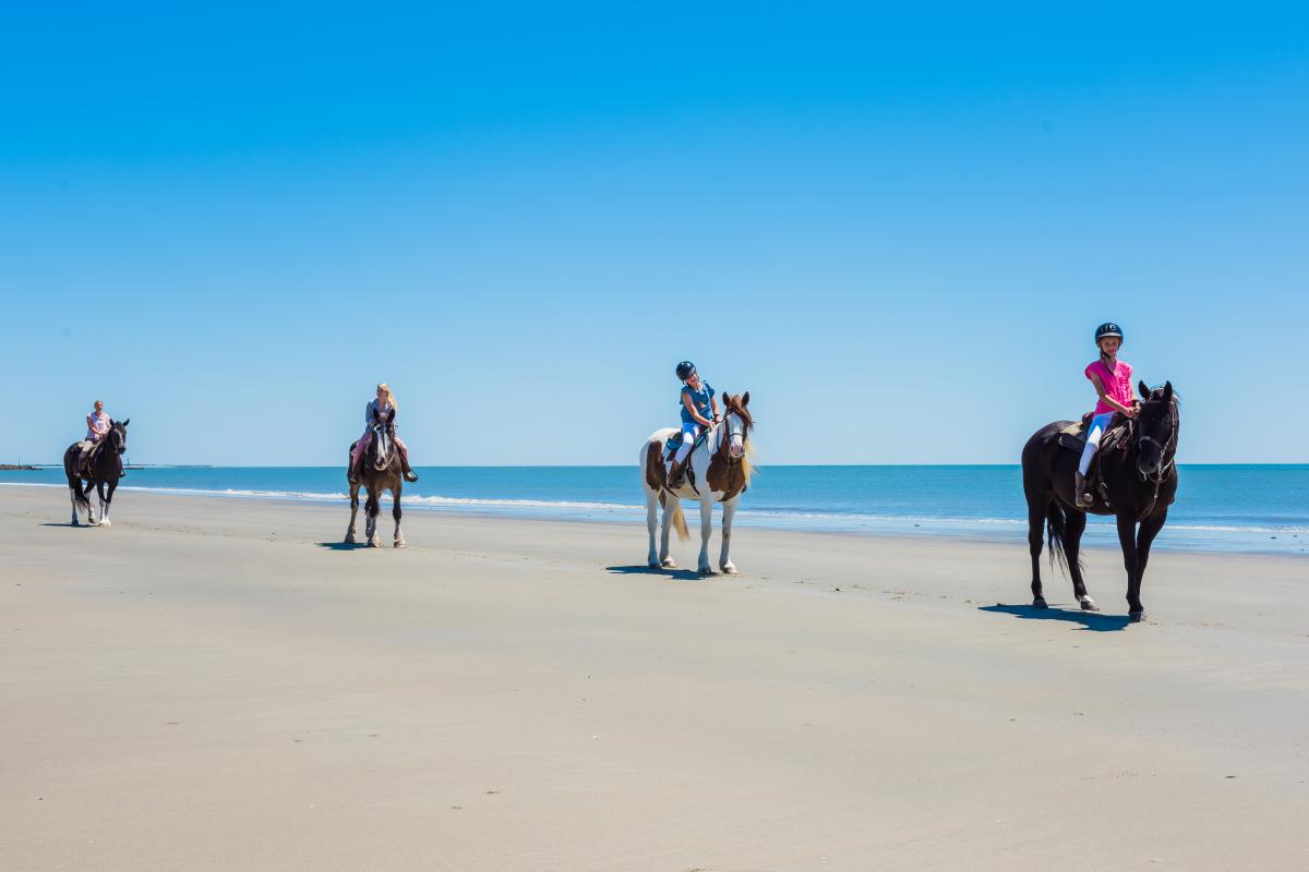 Kids horseback riding on the beach