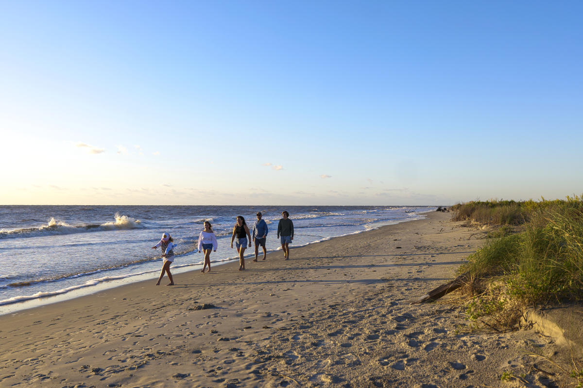 Family walking on a beach in St. Simons Island