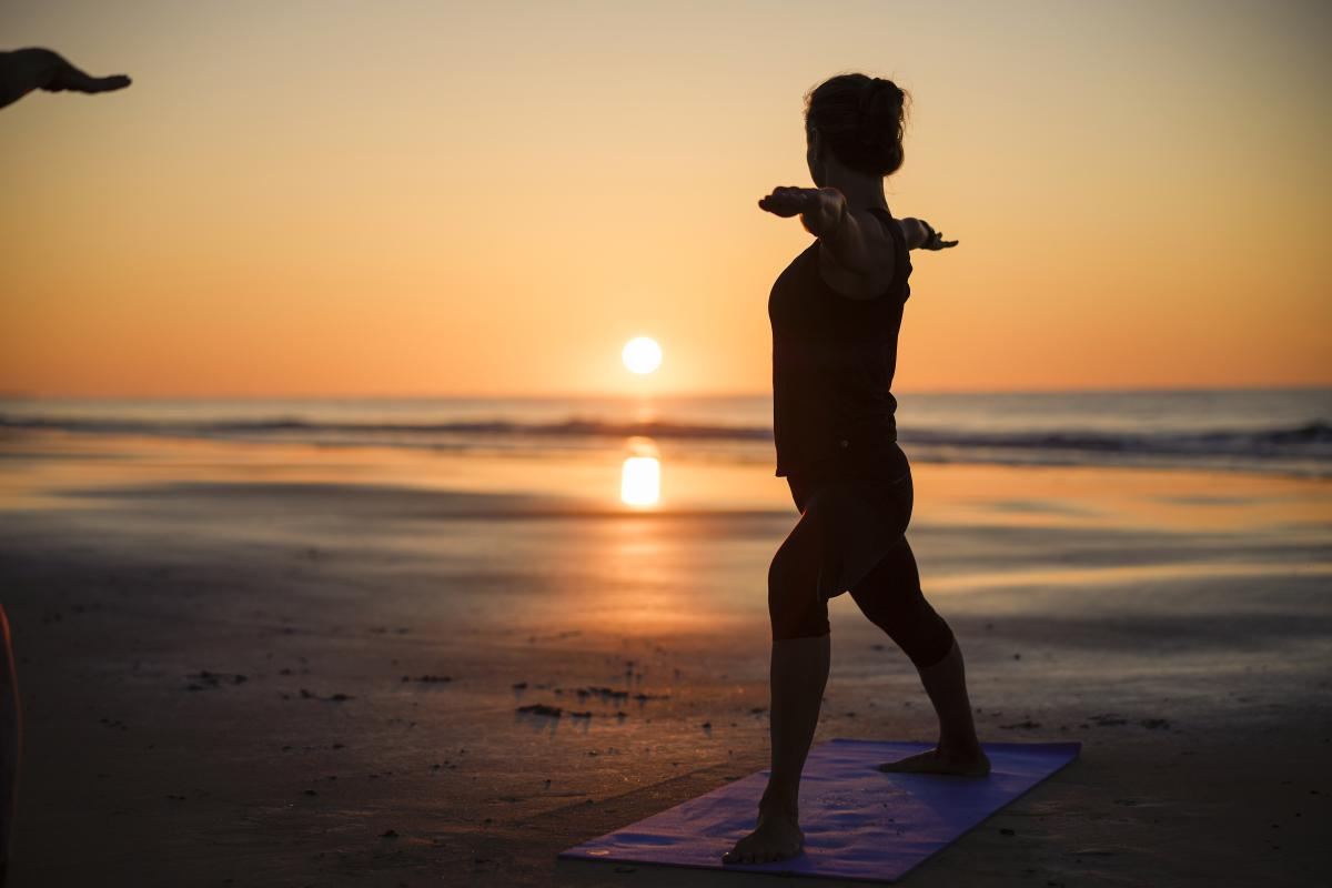 Yoga at sunrise on the beach at St Simons Island, GA Stock Photo