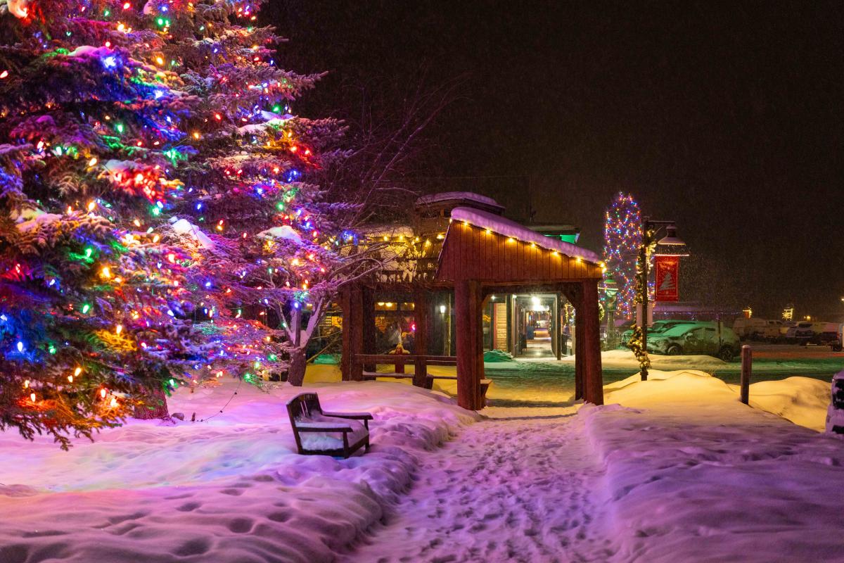 Snow covered boardwalks and twinkling lights on trees and buildings on Grand Avenue in Grand Lake